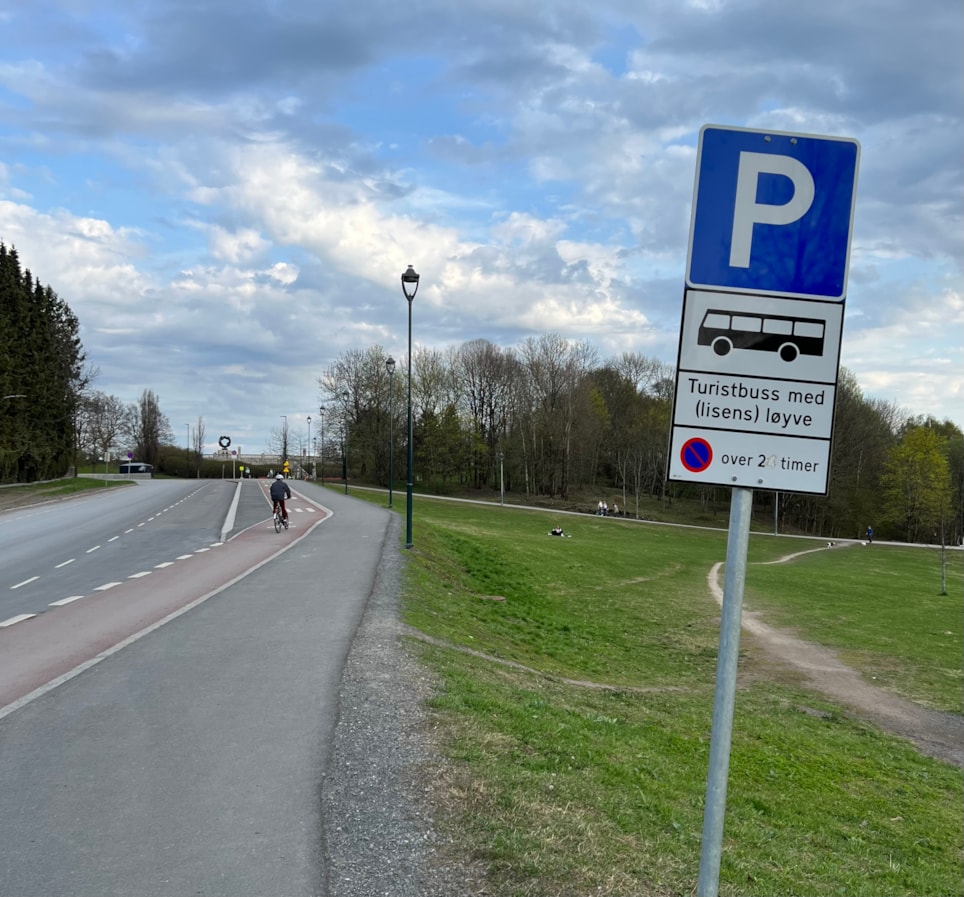 Bildet viser en vei med et skilt for parkering av turbuss