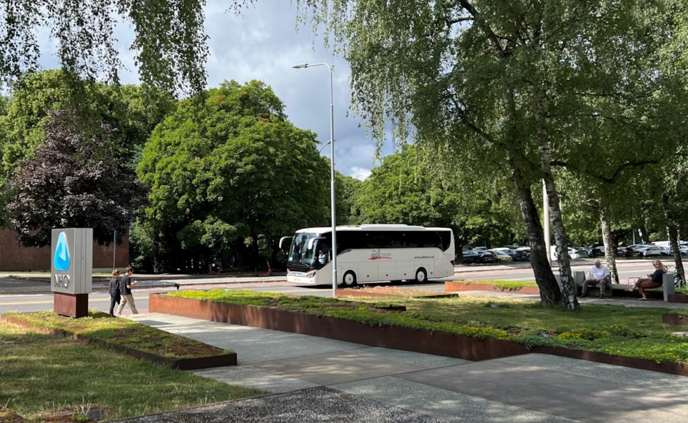 bildet viser en turbuss og grønne trær